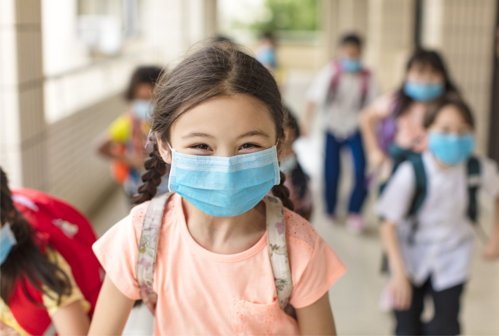Foto de crianças saudáveis e usando máscara em embiente escolar